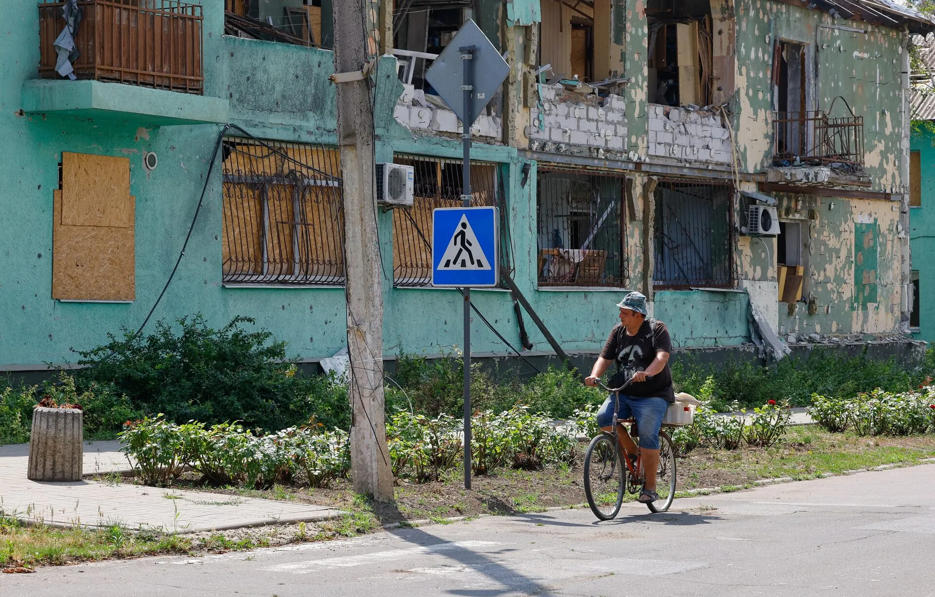Чоловік їде на велосипеді вулицею міста Курахове під час російсько-українського конфлікту в Донецькій області, контрольованій Росією частині України, 18 липня 2025 року.
